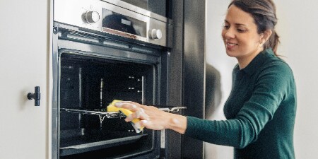 Woman cleaning the overn with Scotch-Brite® Power Classic Laminate Scrub Sponge
