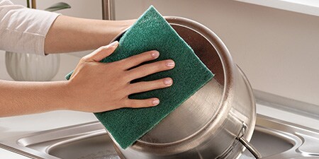  Cleaning stainless steel pot with Scotch-Brite® Heavy Duty Pad

