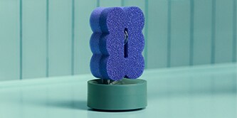 Brite by Scotch-Brite™ Dark Blue Scrub & Wipe Sponge on a sponge holder by the sink.
