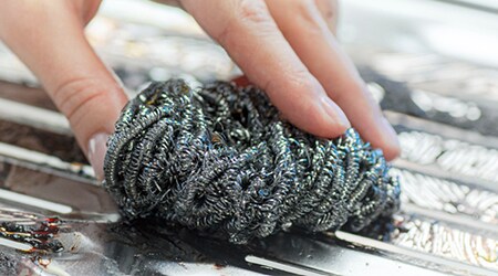 Cleaning grill with Scotch-Brite® Grill Nail Saver Scrub Sponge
