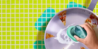 Brite by Scotch-Brite™ Palm Scrubber in use on a frying pan.
