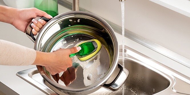 Washing a pot with Scotch-Brite™ Heavy Duty Dishwand
